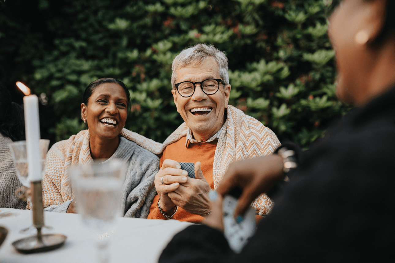 Man and women sitting in the garden laughing with friends