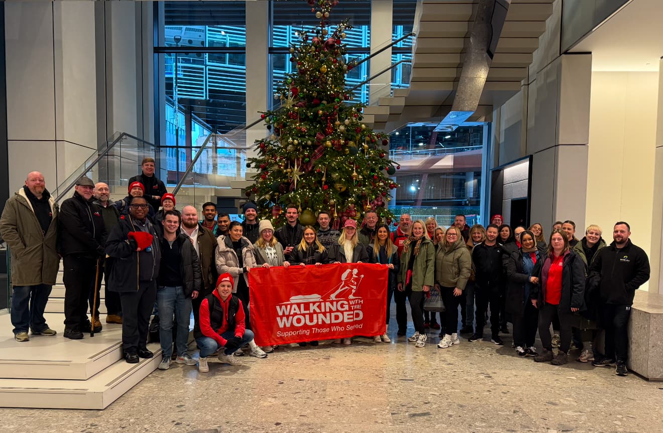 Colleagues standing in front of a Christmas tree in an office