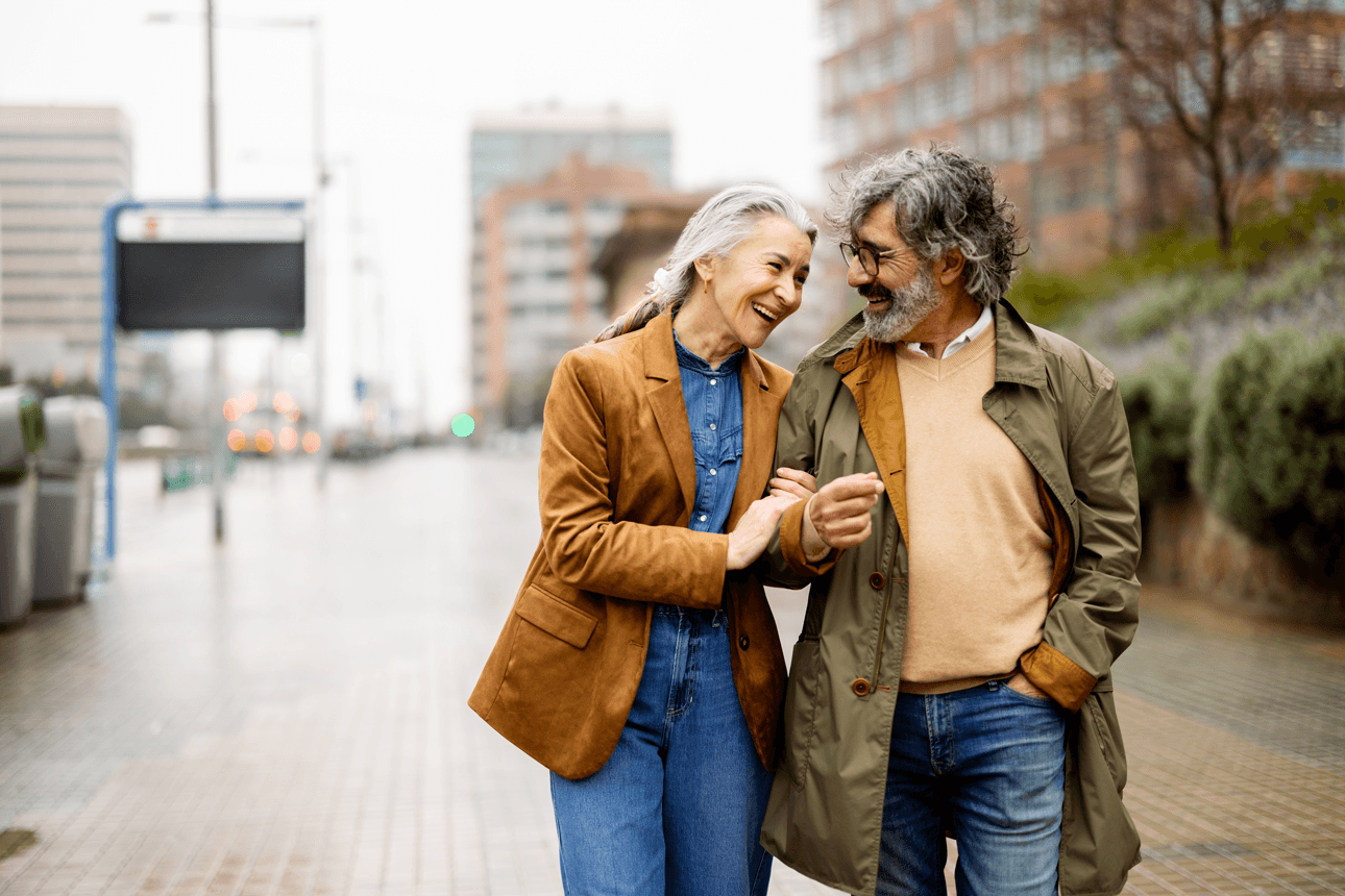 Man and women walking down the street linking arms and laughing