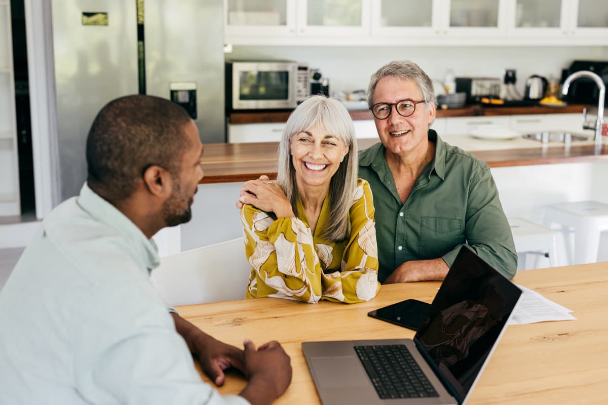 Male adviser speaking with a man and women