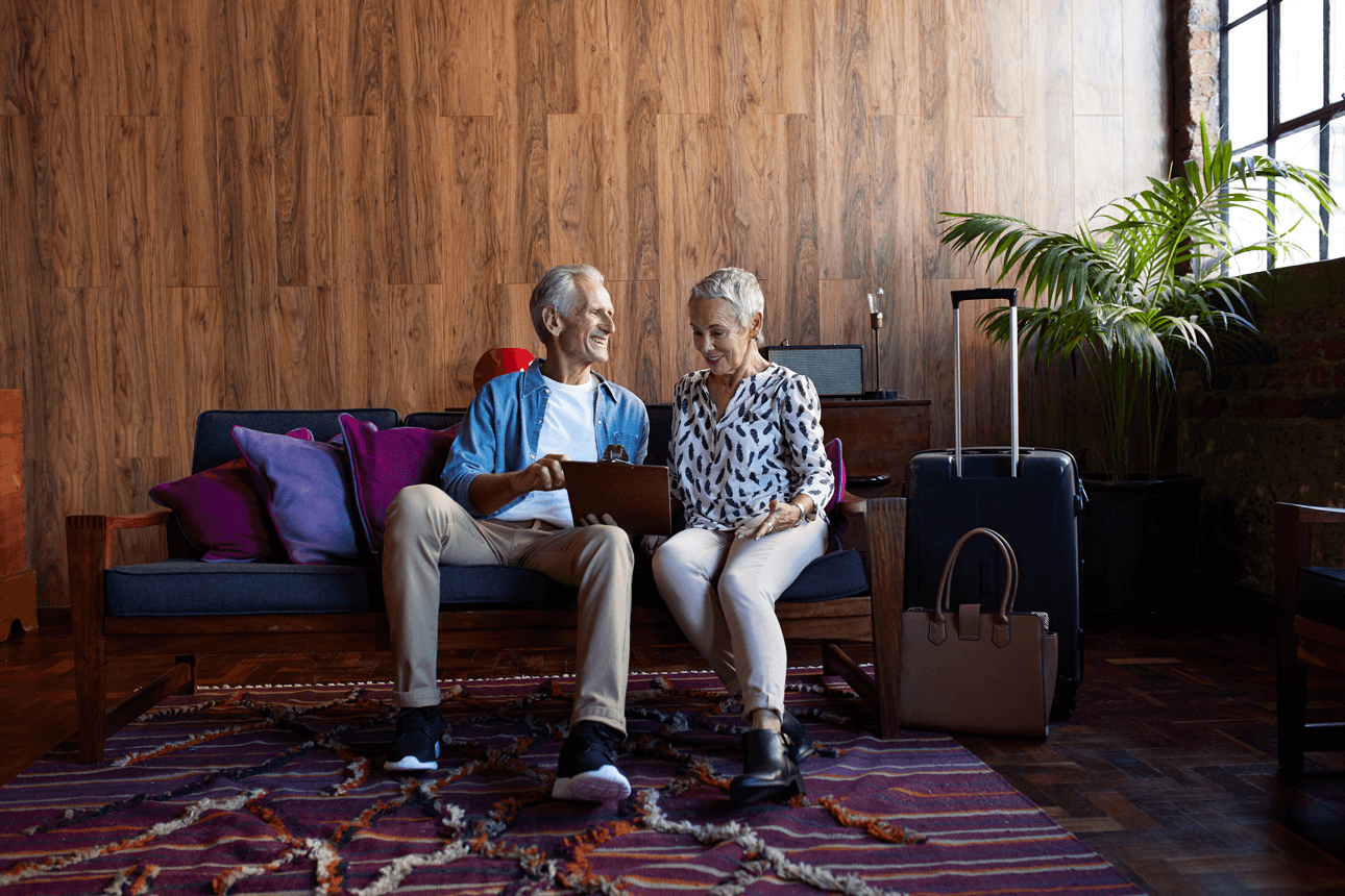 Smiling couple in a hotel lobby filling out forms