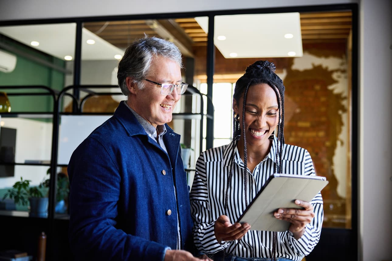 Man and women looking at a tablet laughing